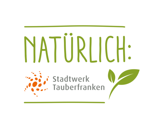 Logo Stadtwerk Tauberfranken Logo mit der Aufschrift „Natürlich Stadtwerk Tauberfranken“ und einem stilisierten grünen Blatt sowie einem orangefarbenen Punkt